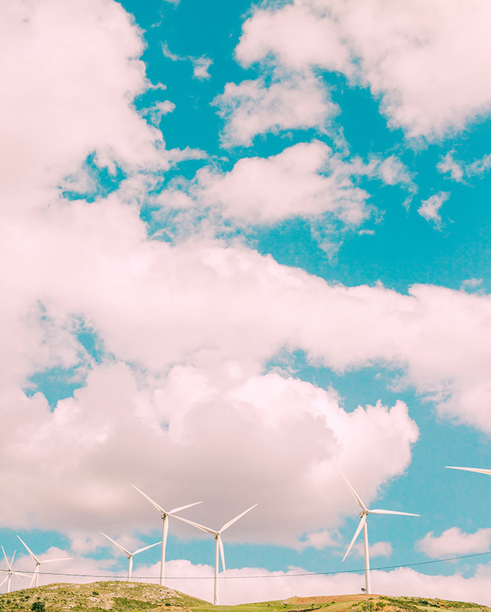 Eine Reihe von Windkraftanlagen erhebt sich unter einem strahlend blauen Himmel mit weißen Wolken. Dieses Bild steht für nachhaltigen Schutz und innovative Lösungen – genau wie die Wohngebäudeversicherung von Voigt Versicherung, die auf individuelle Zusatzbausteine setzt.