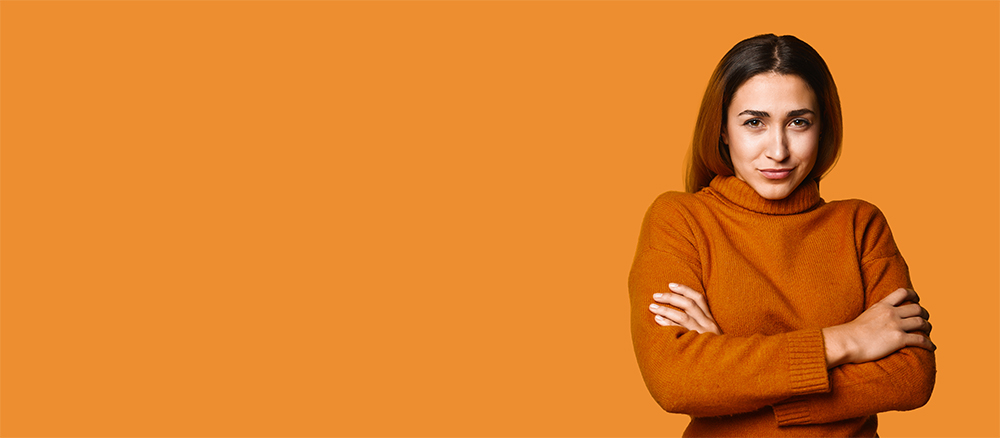 Frau blickt in die Kamera mit verschränkten Armen