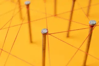 Roter Faden fädelt sich um Nägel