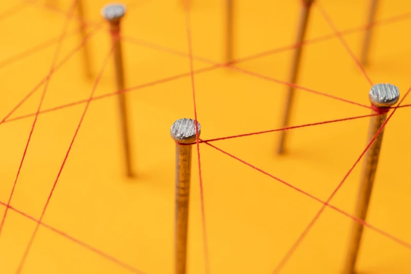Roter Faden fädelt sich um Nägel